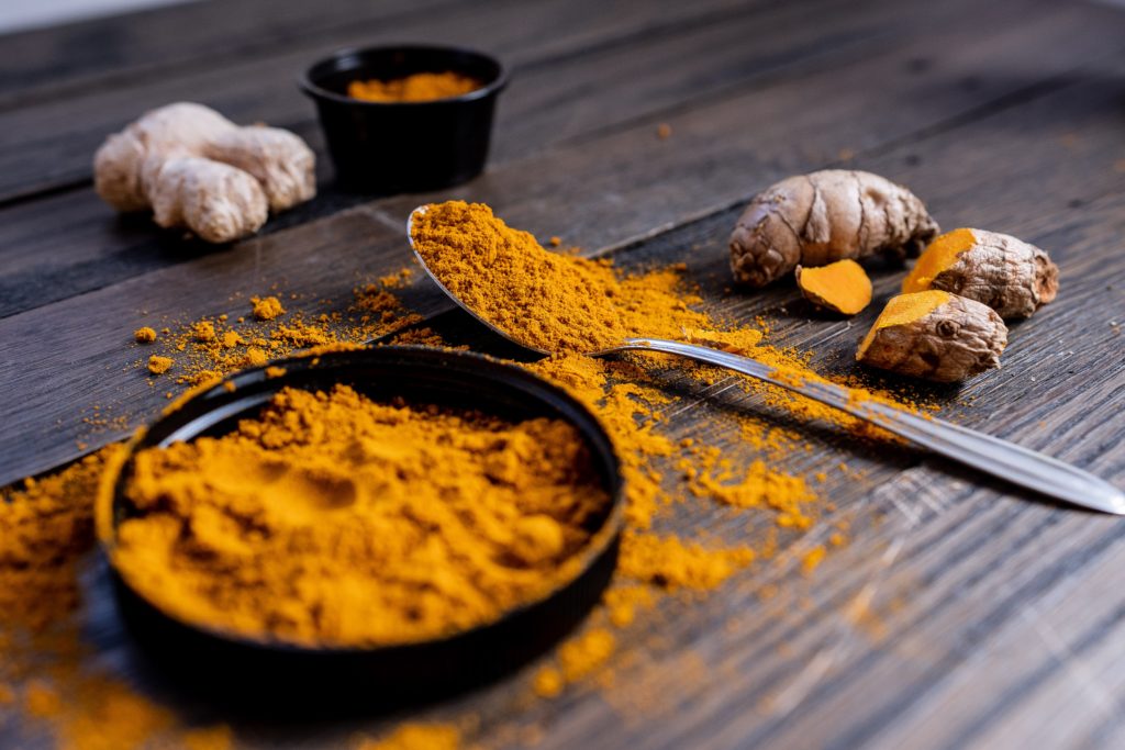 Turmeric root and powder on a table, the staples for making jamu, a turmeric juice with plenty of benefits
