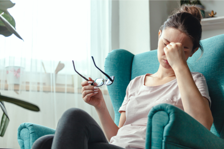 woman sitting in an armchair having symptoms of fatigue