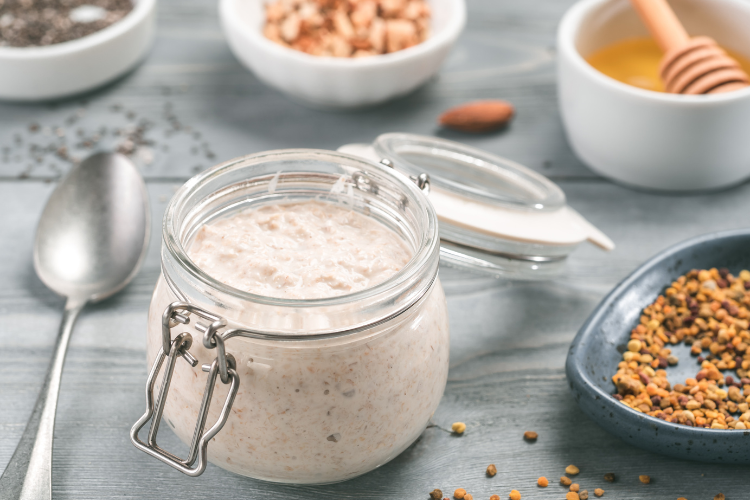 A Mason jar of creamy overnight oats on a table with other dishes