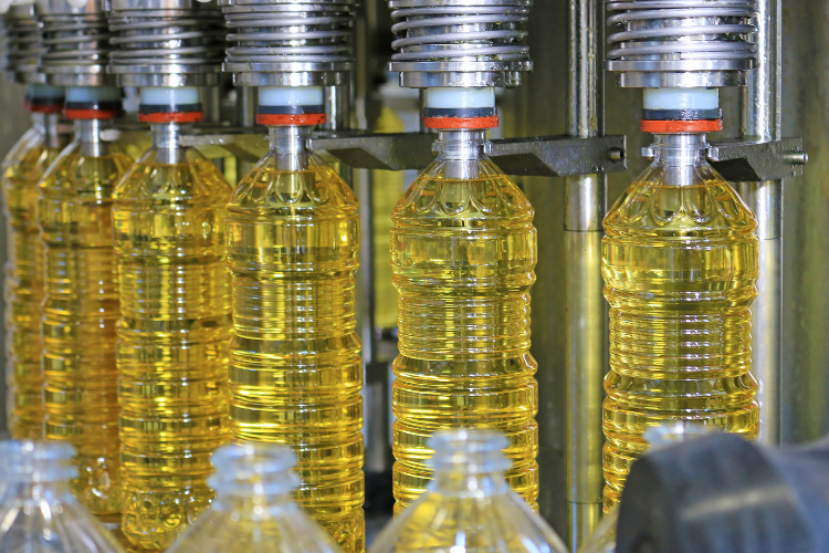 plastic bottles being filled with sunflower seed oils in a factory