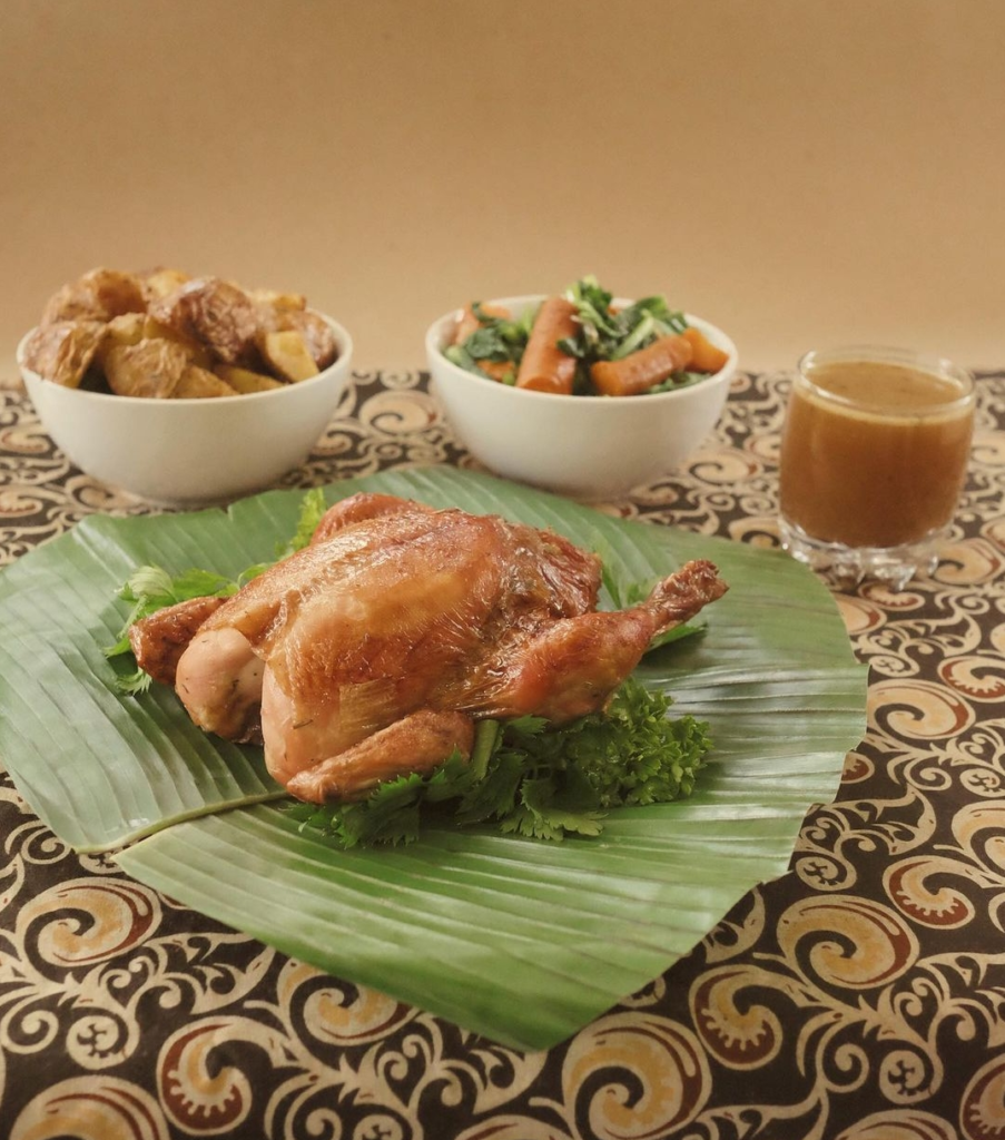 Bali Buda Roasted chicken served on a table with a side of potatoes, vegetables and gravy