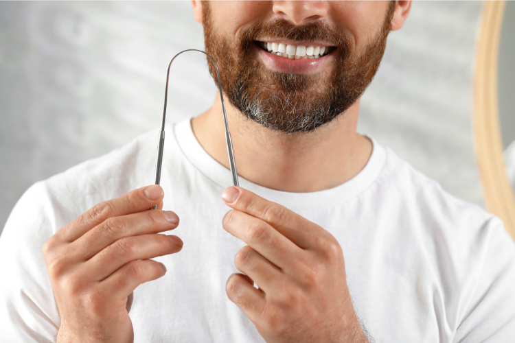 A man holding a tongue cleaner with both hands